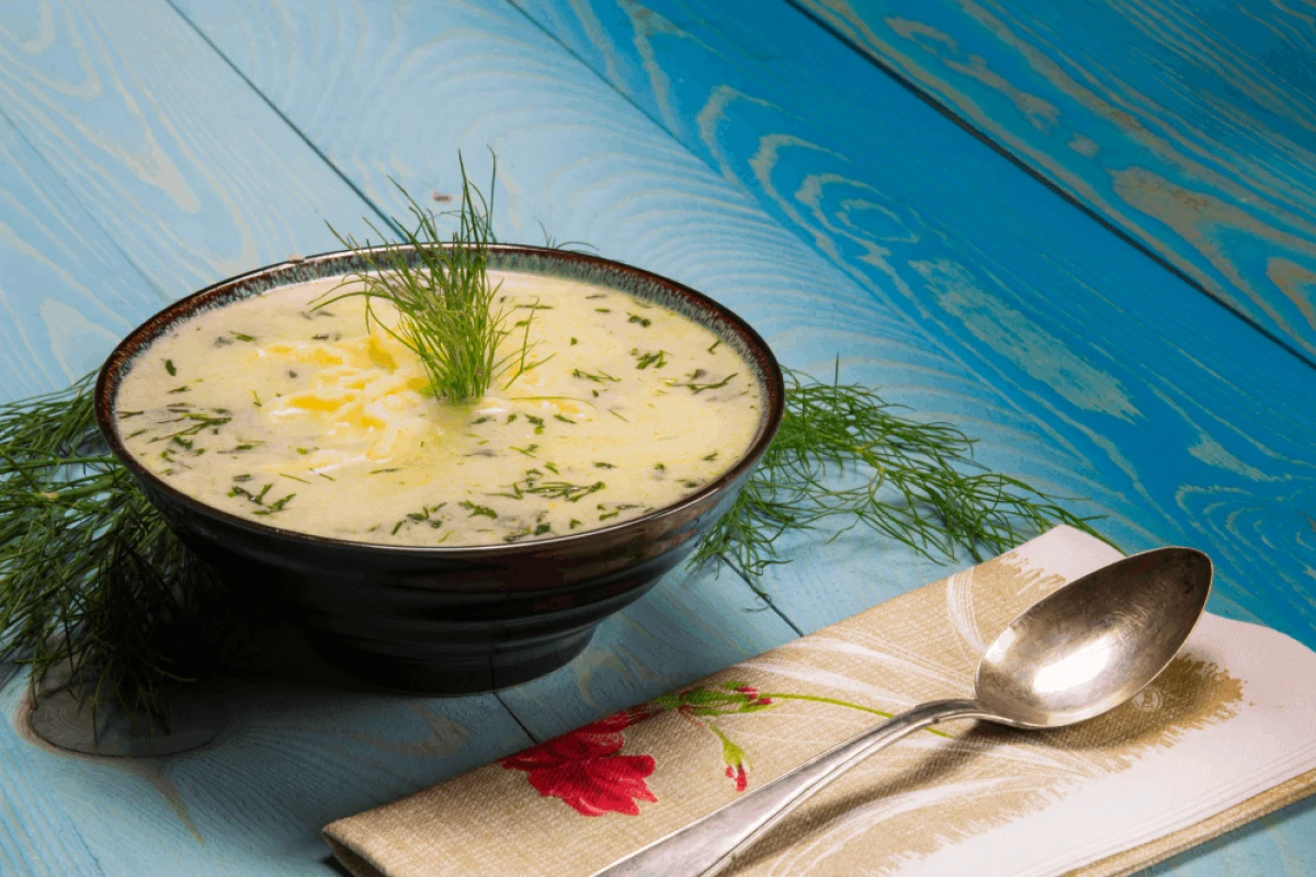 Zupa koperkowa w czarnej misce na niebieskim tle